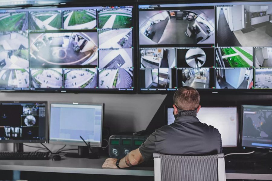 Opérateur devant un mur d'écrans de vidéosurveillance